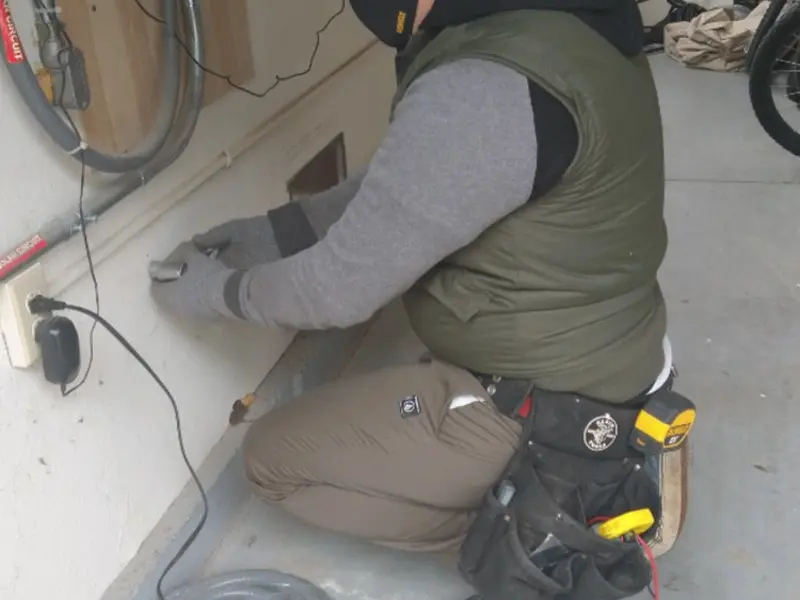 Electrician performing outlet wiring in a White Creek garage